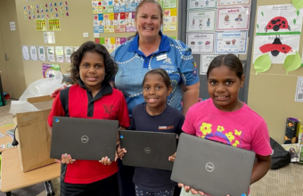 Three young female students from Bloomfield River State School with their donated laptops from GIVIT and a female teacher