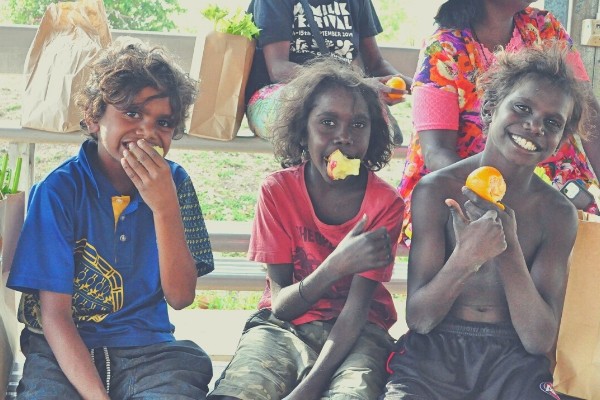Three young Indigenous boys eating fruit in Barunga, Northern Territory