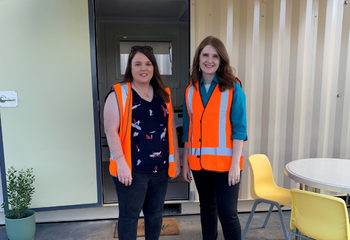 GIVIT Engagement Officer Breanna standing with Issy from North Coast Community Housing in front of a temporary housing pod