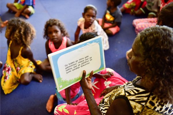 An Indigenous educator reading to First Nations children in language