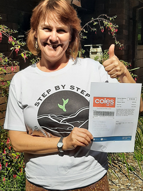 A staff member from Step By Step Recovery Agency with Coles vouchers