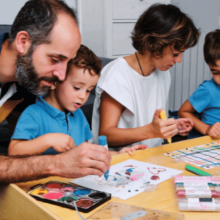 Two young boys drawing and painting with their mum and dad
