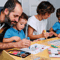 Two young boys drawing and painting with their mum and dad