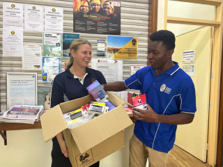 A male and female staff member from MWW excitedly opening a box full of phones and sim cards.