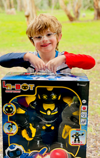 A young smiling boy holding a new robot toy that's been given to him