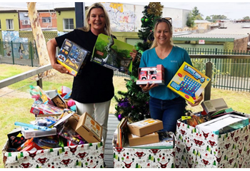 Linda from Haweskbury's Helping Hands and Kirsty from GIVIT holding toys donated by Narwee Public School students