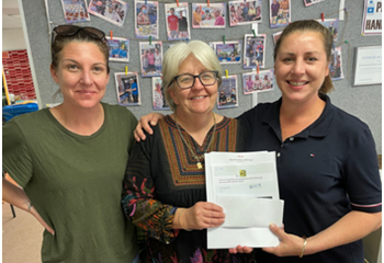 Two ladies with Melinda from Yeronga Community Centre, holding vouchers from GIVIT to buy new household essentials.
